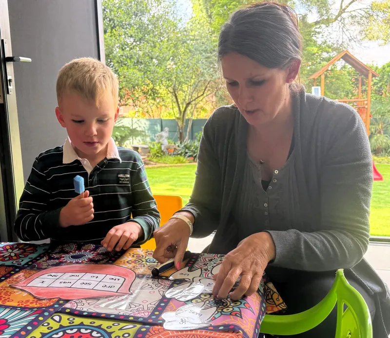 A Starbound educator and a boy play a sight-word game together